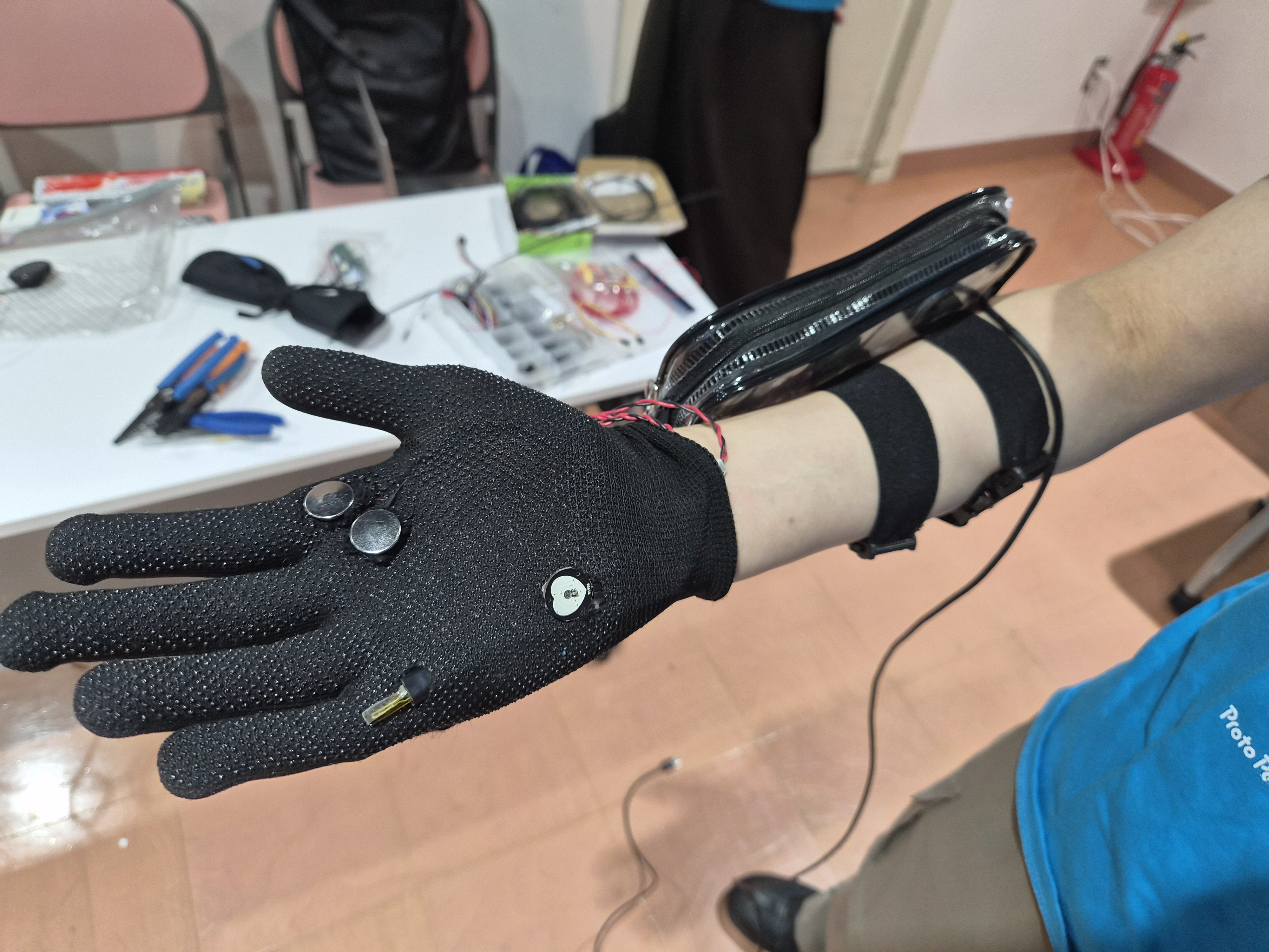 複数のセンサーを取り付けた黒いグローブの手のひら側